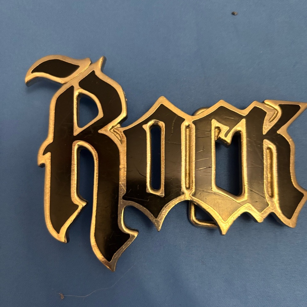 Beautiful vintage belt buckle featuring the word “Rock” in black.